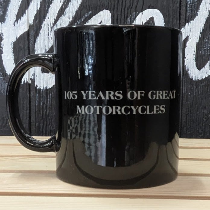 Black mug with text on a wooden surface and dark background