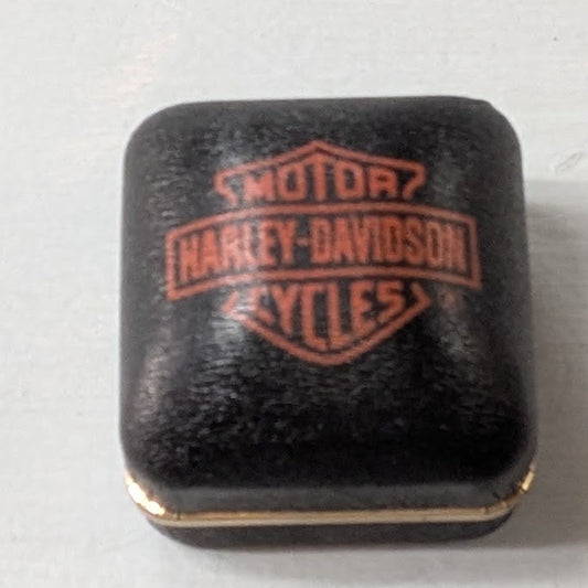 A small black square product with a raised Harley-Davidson Motor Cycles logo in red-orange, photographed on a plain light background.
