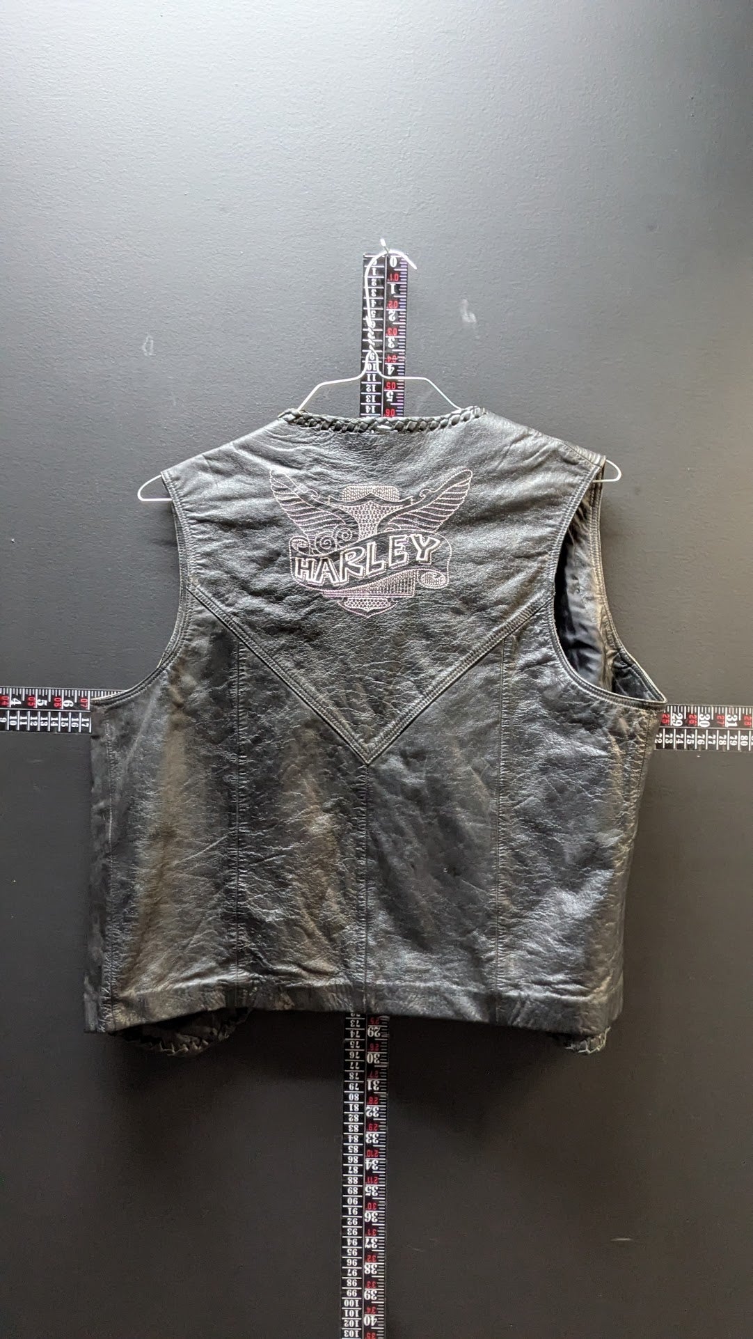 Gray sleeveless jacket with branding on a gray background