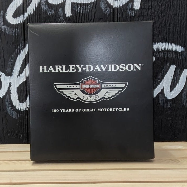 Harley-Davidson box on a wooden surface with a black background featuring white text.