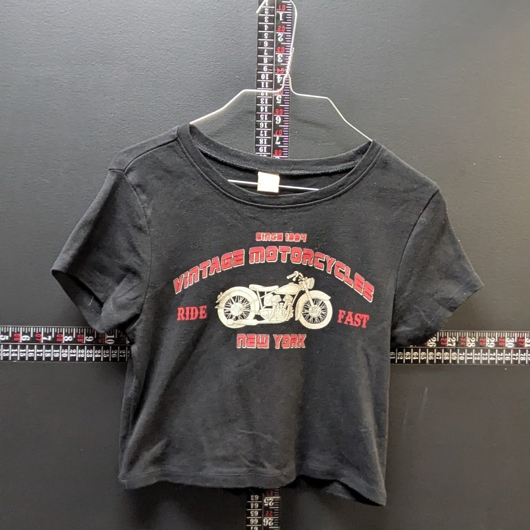 Gray t-shirt with red and white graphic design on a hanger against a dark background