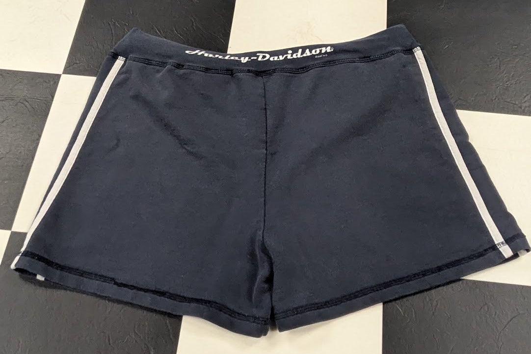 A pair of dark navy blue athletic shorts with white side stripes and a white waistband logo, laid flat on a black and white checkered floor. The brand 'Chaps' is visible on the waistband.