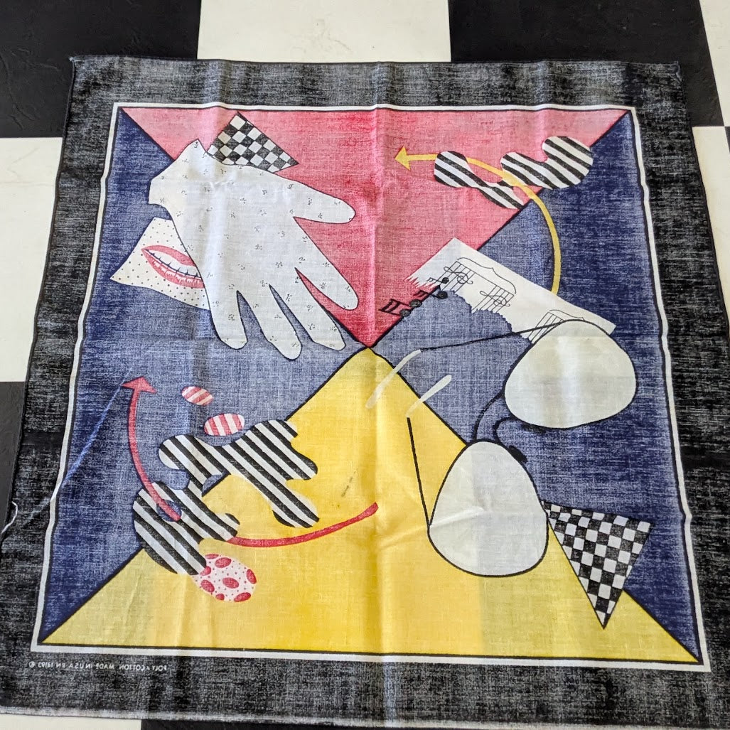 A square vintage-style art print or textile panel featuring a colorful abstract composition with geometric shapes, a white hand, sunglasses, lips, and black-and-white checkered details, displayed on a black-and-white checkered floor.
